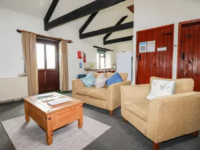 a living room with two chairs and a coffee table at Ravens Croft in Lanivet