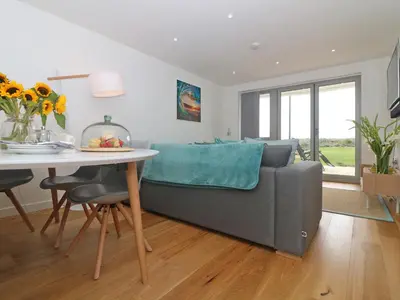 a living room with a couch and a table at Saltwater, One Lusty Glaze in Newquay