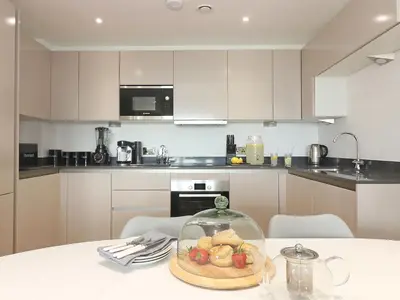a kitchen with a table with a bowl of fruit on it at Saltwater, One Lusty Glaze in Newquay