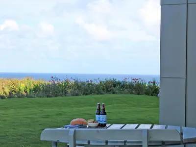 two bottles of beer sitting on a table with a view of the ocean at Saltwater, One Lusty Glaze in Newquay