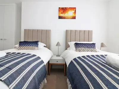 two beds sitting next to each other in a bedroom at Saltwater, One Lusty Glaze in Newquay