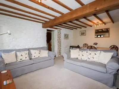 a living room with two couches and a table at 4 Mowhay Cottages in Saint Goran