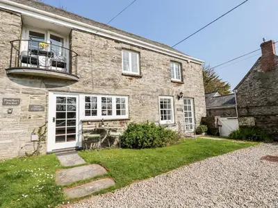 an old brick house with a balcony and a yard at Slate Cottage in Helland