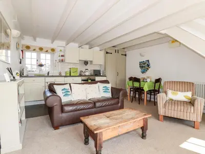 a living room with a couch and a table at Slate Cottage in Helland