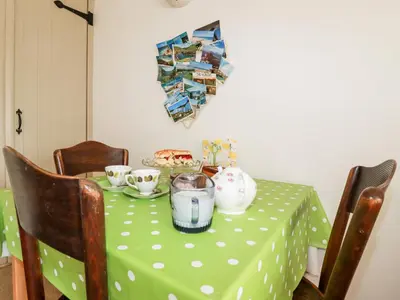 a table with a green polka dot table cloth at Slate Cottage in Helland