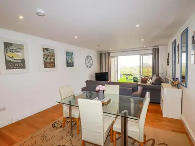 a living room with a glass table and a couch at 47 Bredon Court in Newquay