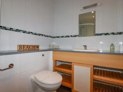 a bathroom with a toilet and a sink and a mirror at 47 Bredon Court in Newquay