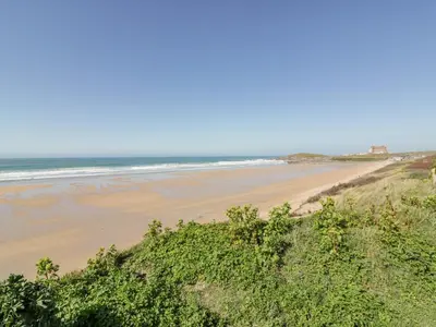 a sandy beach with the ocean in the background at 47 Bredon Court in Newquay
