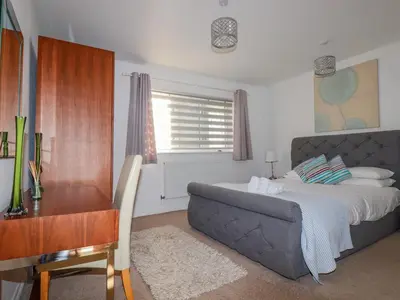 a bedroom with a bed and a desk and a table and chair at 47 Bredon Court in Newquay