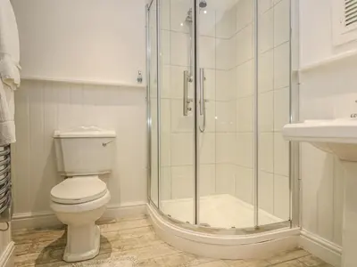 a bathroom with a shower and a toilet and a sink at The Watch Below in Polruan