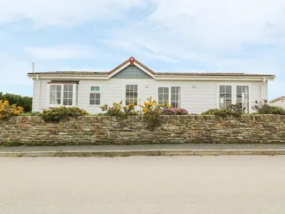 a white house with a stone wall at 11 Pendarves in St Merryn