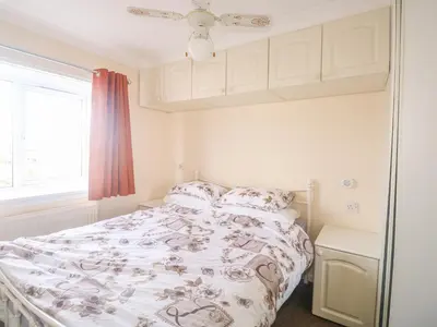 a bedroom with a bed with a comforter on it at 11 Pendarves in St Merryn
