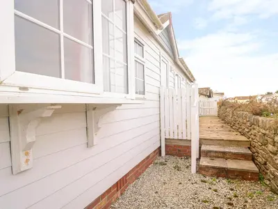 a white house with a window and stairs at 11 Pendarves in St Merryn