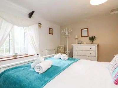 a bedroom with a bed with towels on it at Tinners Cottage in Saint Cleer
