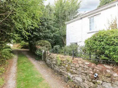 a stone wall in front of a house at Tinners Cottage in Saint Cleer