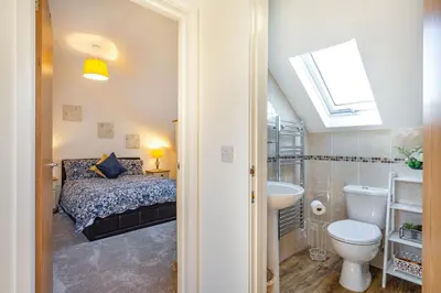 a bathroom with a bed and a sink and a toilet at The Litte Hideaway in Saint Columb Minor