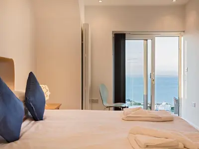 a bedroom with a bed with a view of the ocean at Boscarne in St Ives