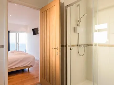 a bathroom with a shower and a glass door at Boscarne in St Ives