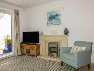 a living room with a chair and a television at 5 Ocean Heights in Newquay