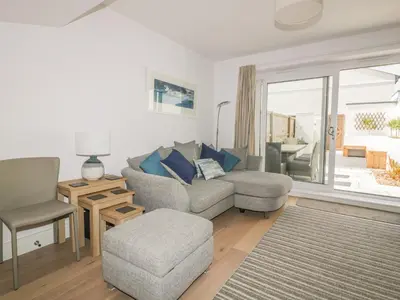a living room with a couch and a chair at 5 Ocean Heights in Newquay