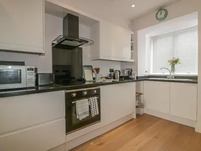 a kitchen with white cabinets and a stove top oven at 5 Ocean Heights in Newquay
