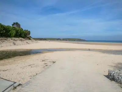 a sandy beach with a path leading to the ocean at 7 Harlyn Cottages in St Merryn