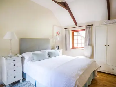 a bedroom with a white bed and a window at The Bullshed in Saint Erth