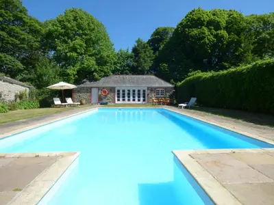 a large swimming pool in front of a house at Flower House in Saint Erth