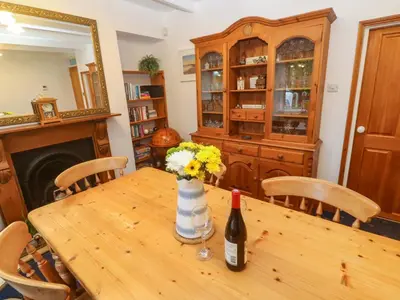 a table with a bottle of wine and flowers on it at Angarrack Farmhouse in Hayle