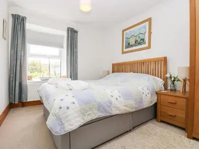 a bedroom with a bed and a window at Angarrack Farmhouse in Hayle