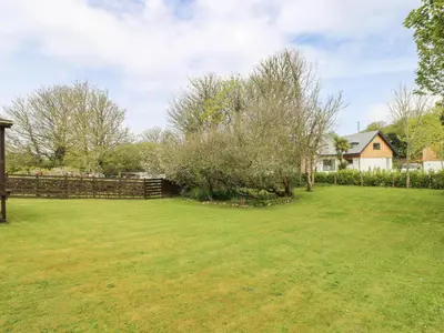 a large yard with a fence and a house at Angarrack Farmhouse in Hayle
