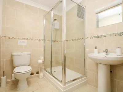a bathroom with a shower and a toilet and a sink at Angarrack Farmhouse in Hayle