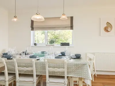a dining room with a table and chairs and a window at Seaport Lodge in Mawgan Porth