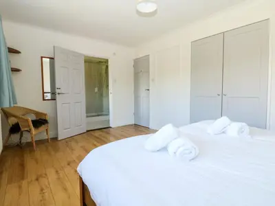 a white bedroom with two white towels on a bed at Seaport Lodge in Mawgan Porth