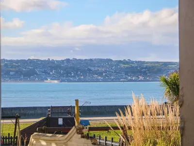a view of the ocean with a bench on the beach at Mackerel Sky in Marazion