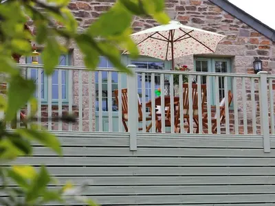 a porch with chairs and an umbrella on a house at Omalast in Truro
