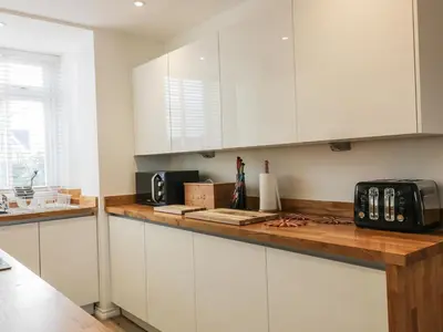 a kitchen with white cabinets and a counter top at Fistral Breeze in Newquay