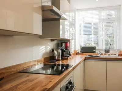 a kitchen with a sink and a stove top oven at Fistral Breeze in Newquay