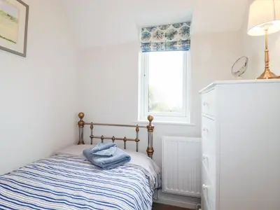 a small bedroom with a bed and a window at Gull Cottage in Padstow
