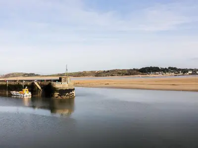 a boat in the water next to a pier at Gull Cottage in Padstow