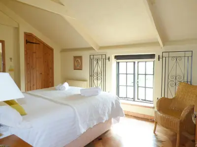 a bedroom with a white bed and a window at Old Winery Cottage in Golant