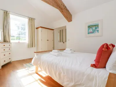 a bedroom with a large white bed and a window at Wheal Grey in Germoe