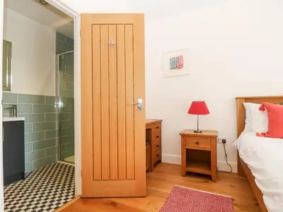 a bathroom with a door leading to a bedroom at Wheal Grey in Germoe