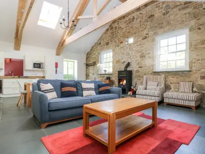 a living room with a blue couch and a table at Wheal Grey in Germoe