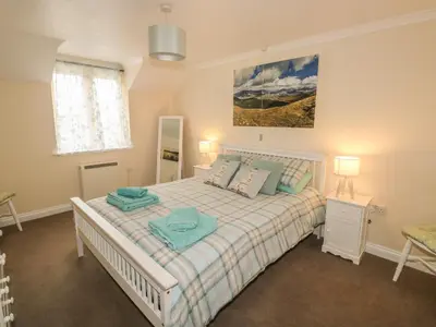a bedroom with a large bed with two towels on it at Kingfisher House in Tintagel