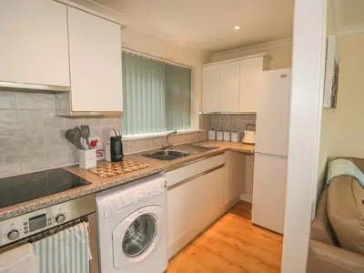 a kitchen with a washing machine and a washer at Kingfisher House in Tintagel