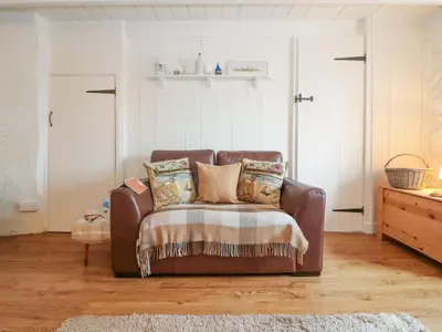 a brown leather couch sitting in a living room at Ner Sea in Marazion