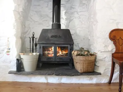 a fireplace in a room with a basket of logs at Ner Sea in Marazion