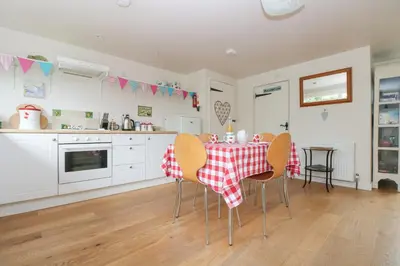 a kitchen with a table with a red and white table cloth at Bolitho's Retreat in Saint Martins Green