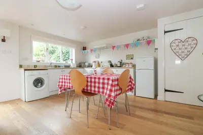 a kitchen with a table with a red and white table cloth at Bolitho's Retreat in Saint Martins Green